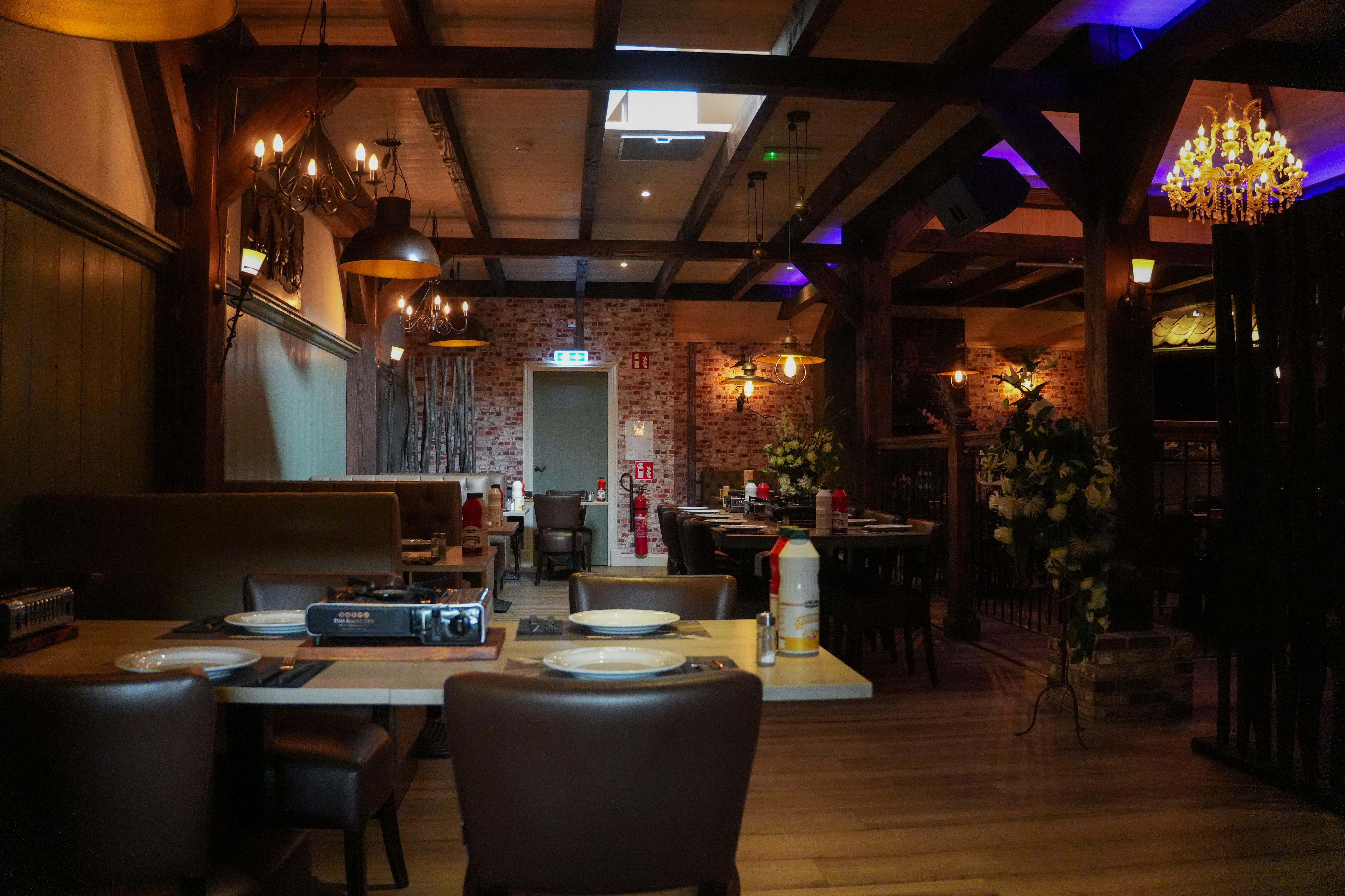 Restaurant de Boerderij — overzicht van de zaal met houten balken en sfeerverlichting
